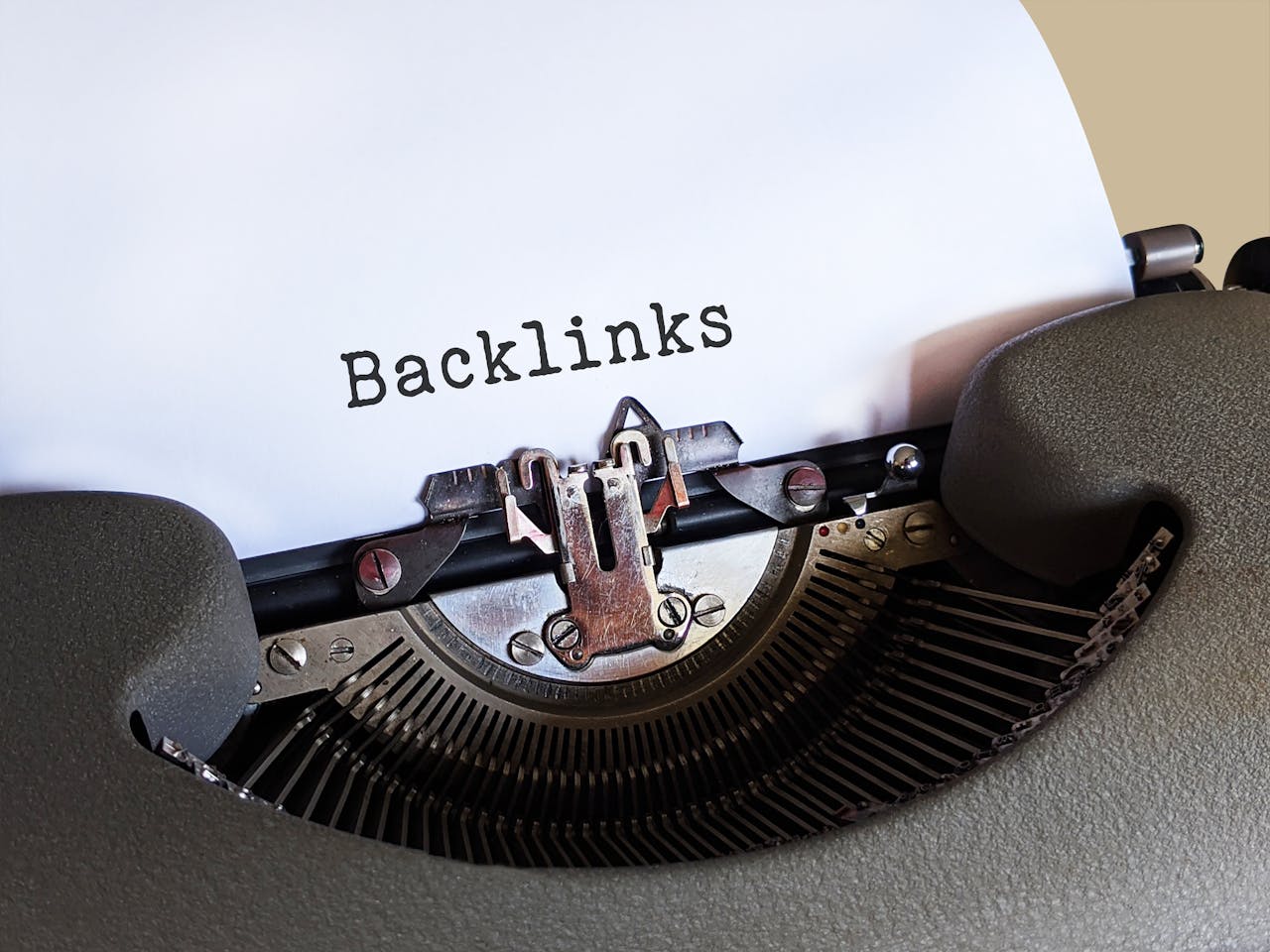 Close-up of a vintage typewriter printing the word Backlinks, emphasizing content and SEO concepts.